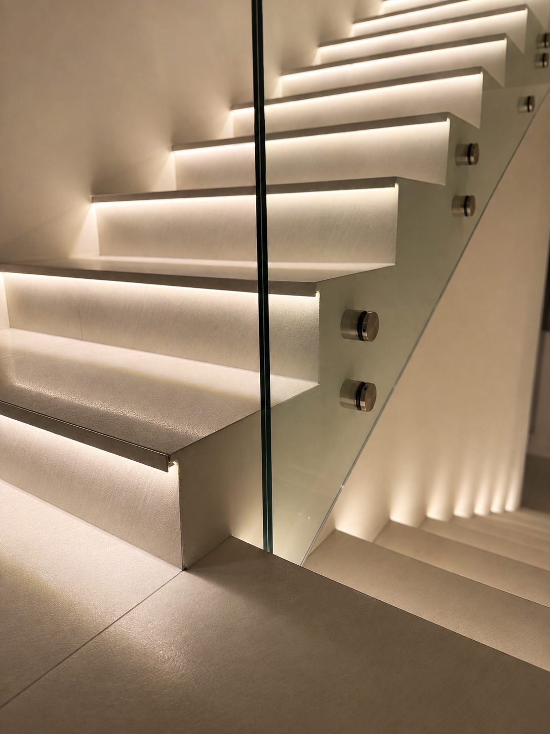Staircase with glass balustrade and light under every step